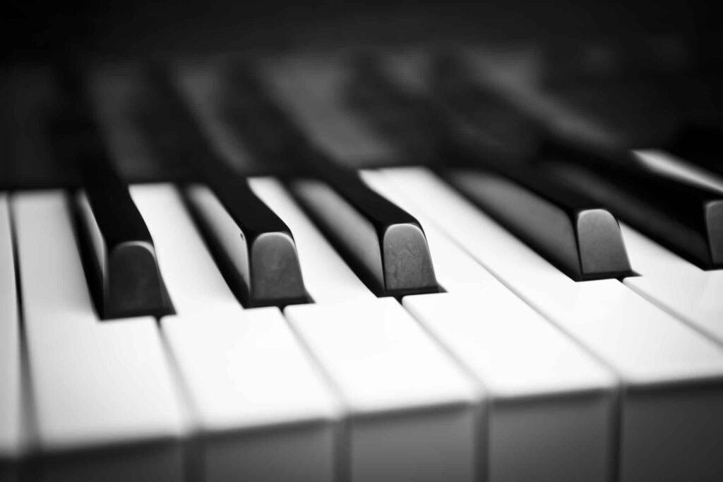 Close-up of a piano keyboard in black and white, focusing on the alternating pattern of black and white keys, with a shallow depth of field.